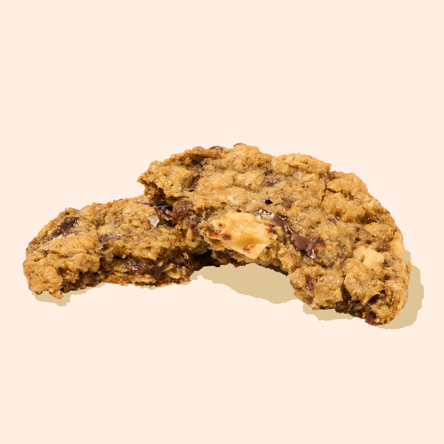 Vegan and Gluten-Free(ish) Oatmeal Chocolate Chip and Walnut cookie on beige background