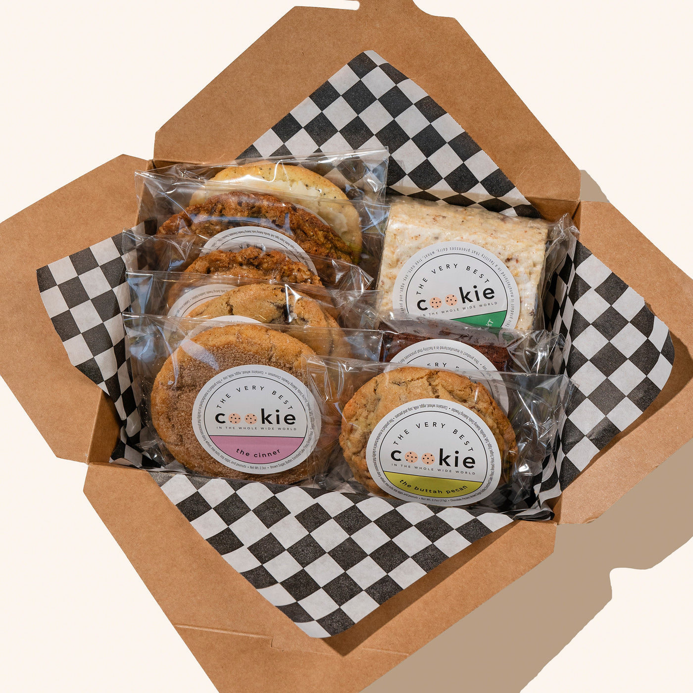 togo box with checkered paper, filled with individually wrapped and stickered cookies