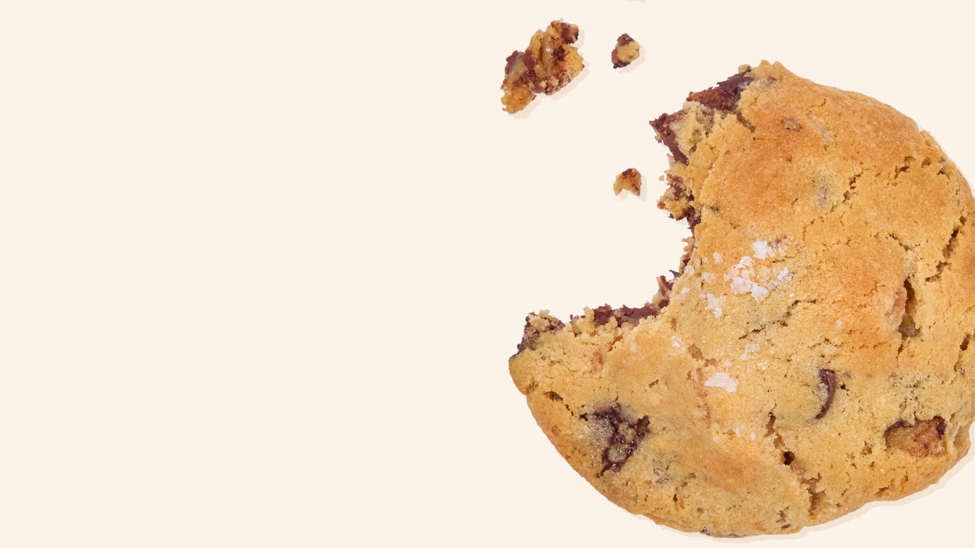 sprouted walnut chocolate chip cookie with a bite taken out and crumbs