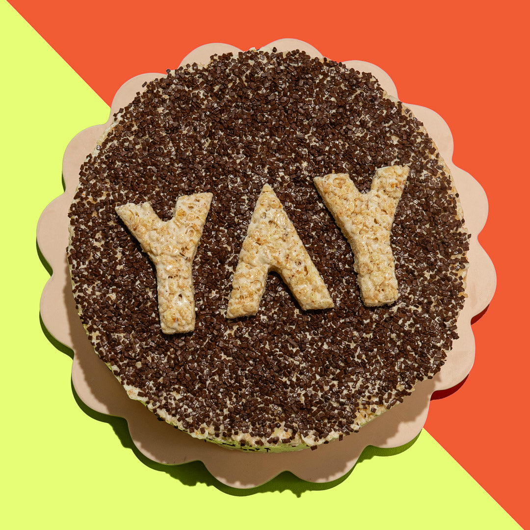 round rice cereal treat cake topped with chocolate sprinkles, and YAY letters