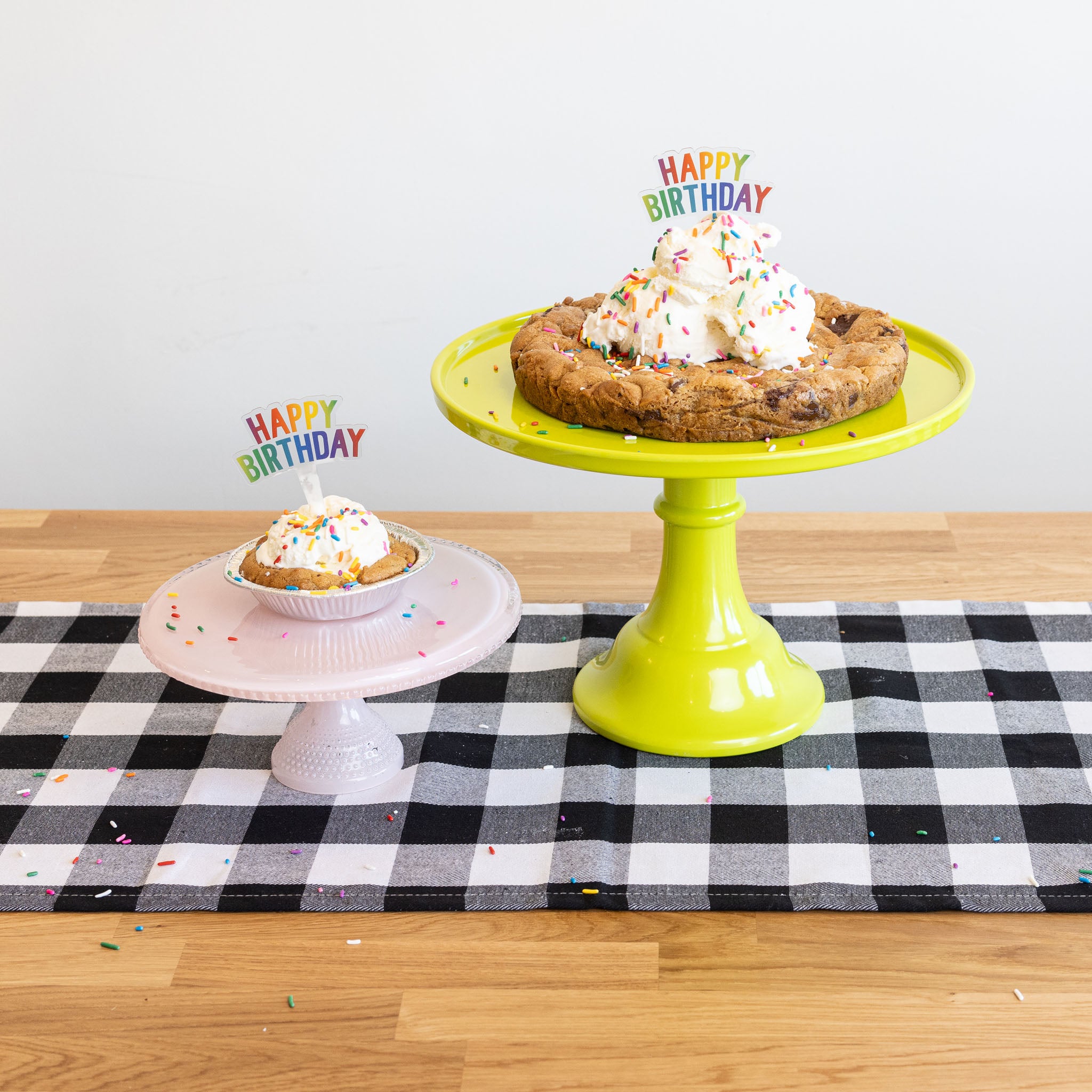 chocolate chip cookie cakes in small and large sizes on cake plate with scoops of vanilla ice cream and happy birthday candles