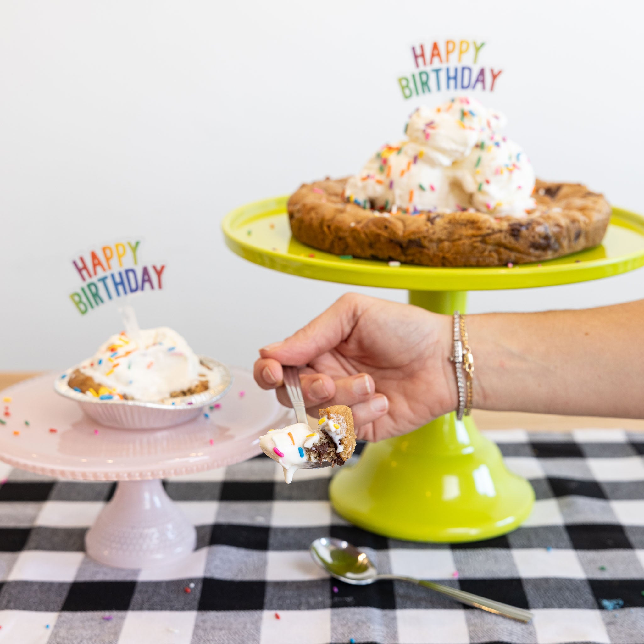 chocolate chip cookie cakes in small and large sizes on cake plate with scoops of vanilla ice cream and happy birthday candles